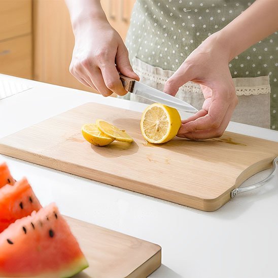 Planche bambou solide en action, découpe légumes, viandes et fruits